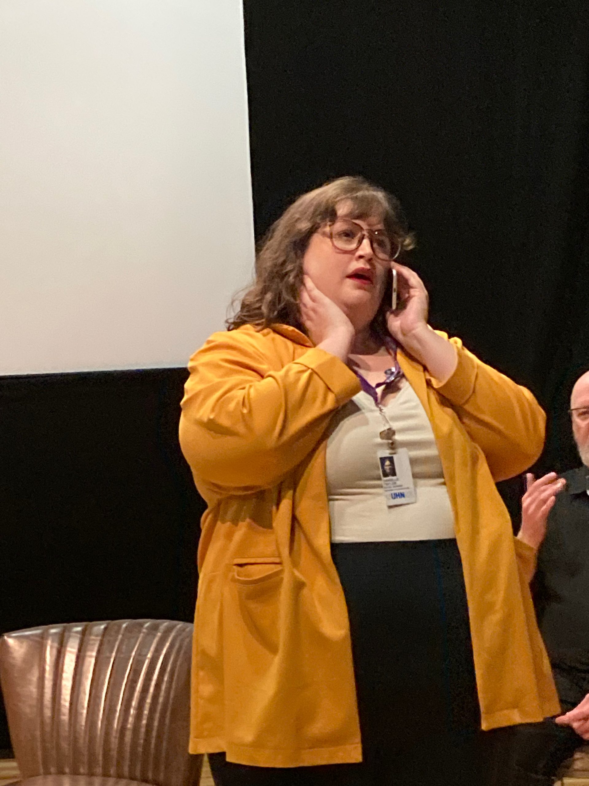 woman on stage talking on a phone